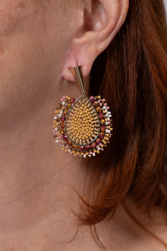 Aros dorados con diseño circular tejido y borde multicolor.