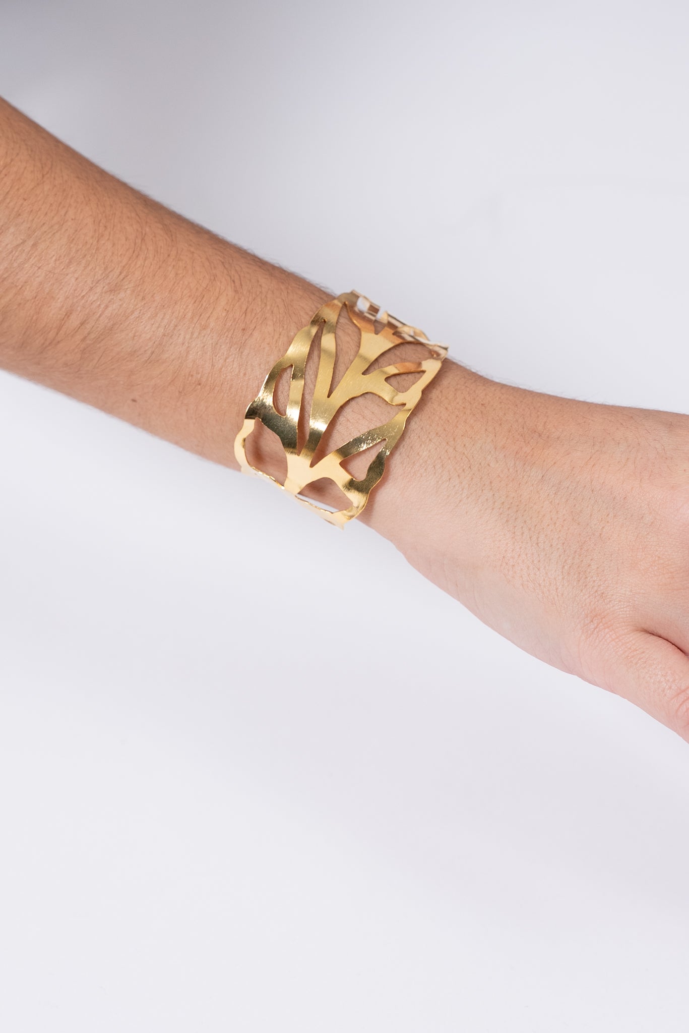 Pulsera dorada con diseño calado estilo hoja.