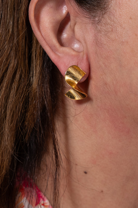 Aros dorados pequeños con diseño ondulado metálico.