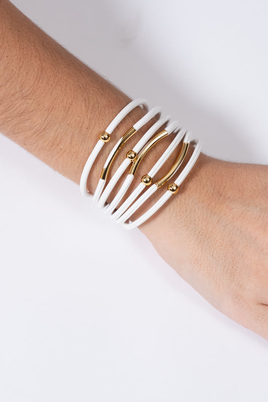 Pulsera elástica con múltiples hilos blancos y detalles dorados al centro.