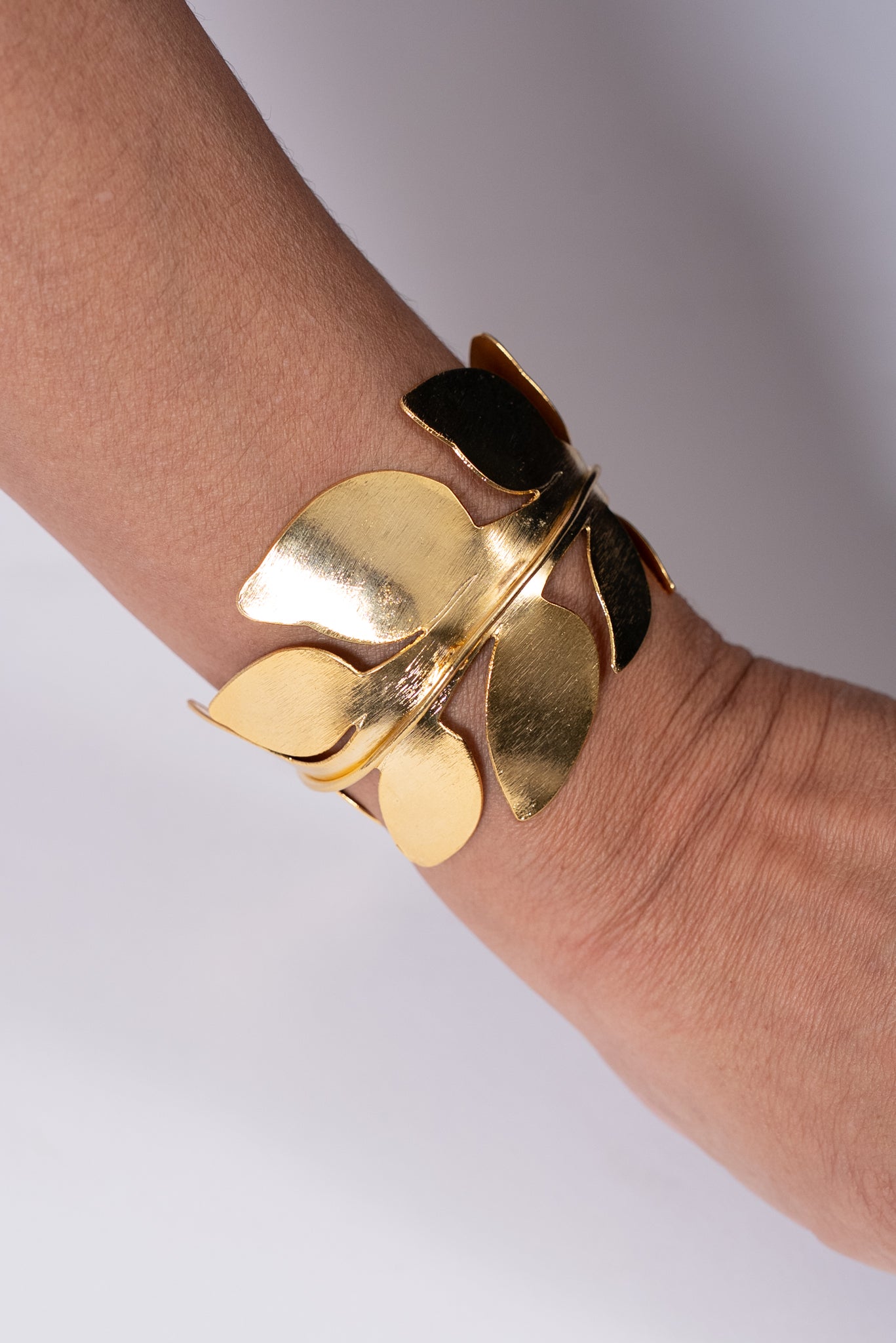 Pulsera dorada con piezas metálicas en forma de pétalos.