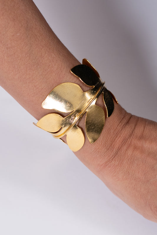 Pulsera dorada con piezas metálicas en forma de pétalos.