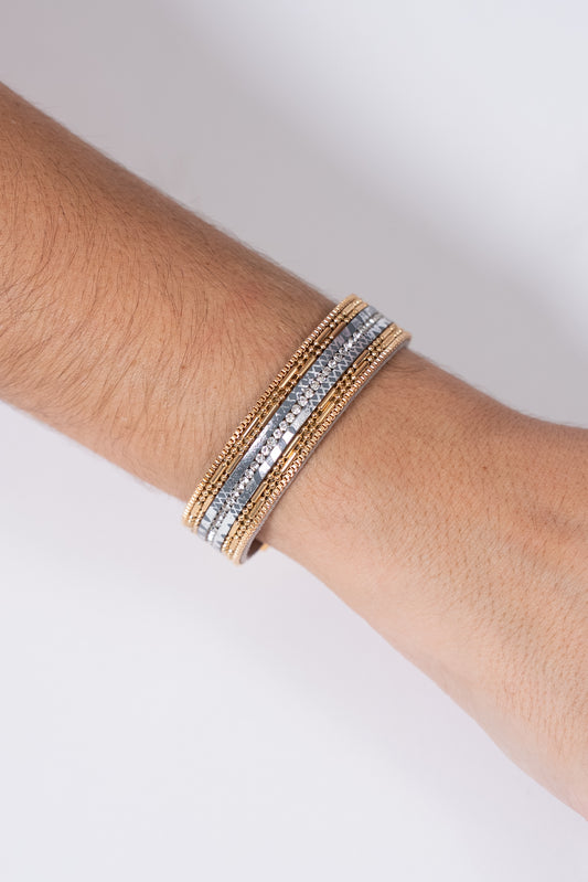 Pulsera dorada con hileras de cuentas en tonos plateado y dorado.