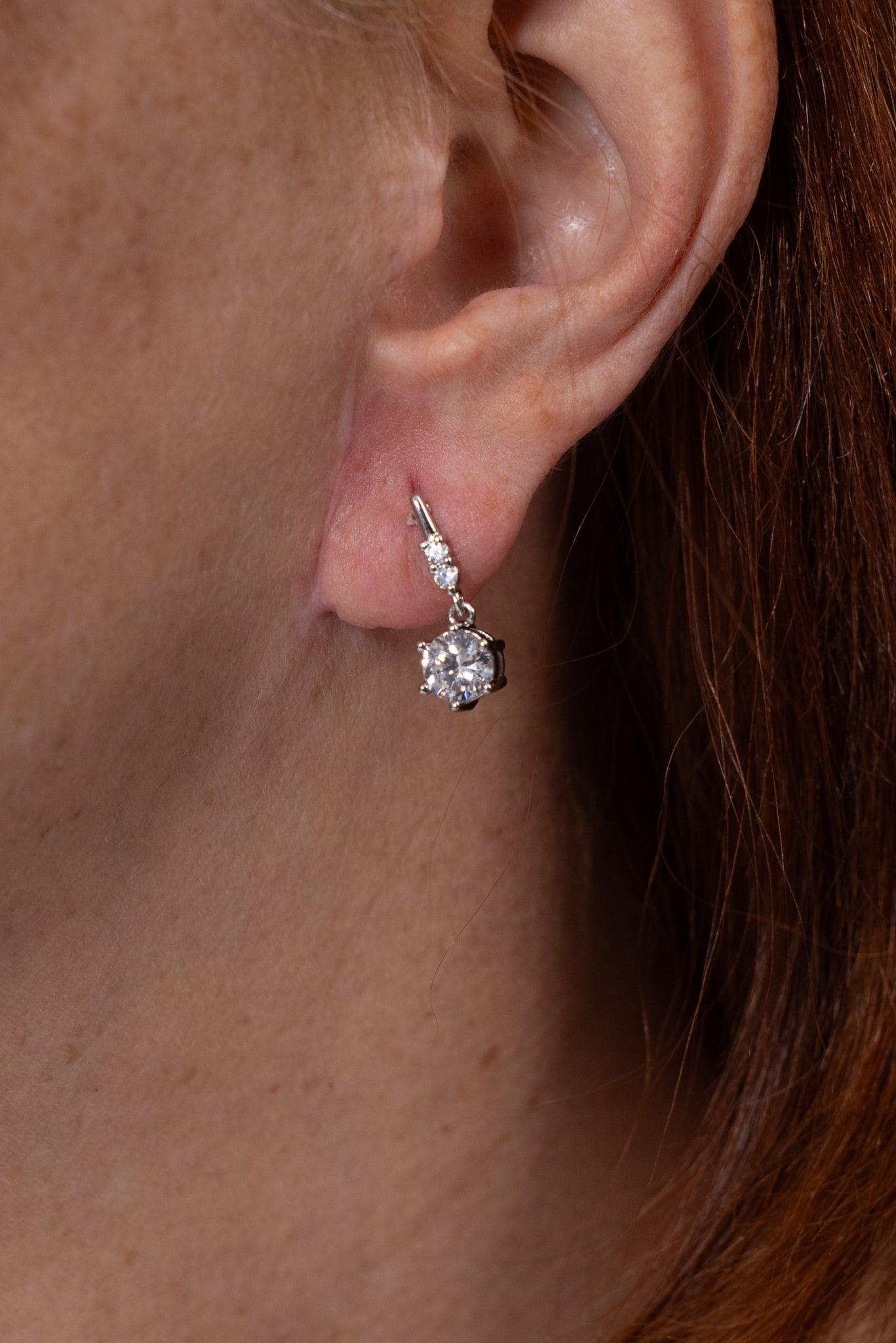 Aros plateados pequeños con colgante de moisanita en corte redondo.