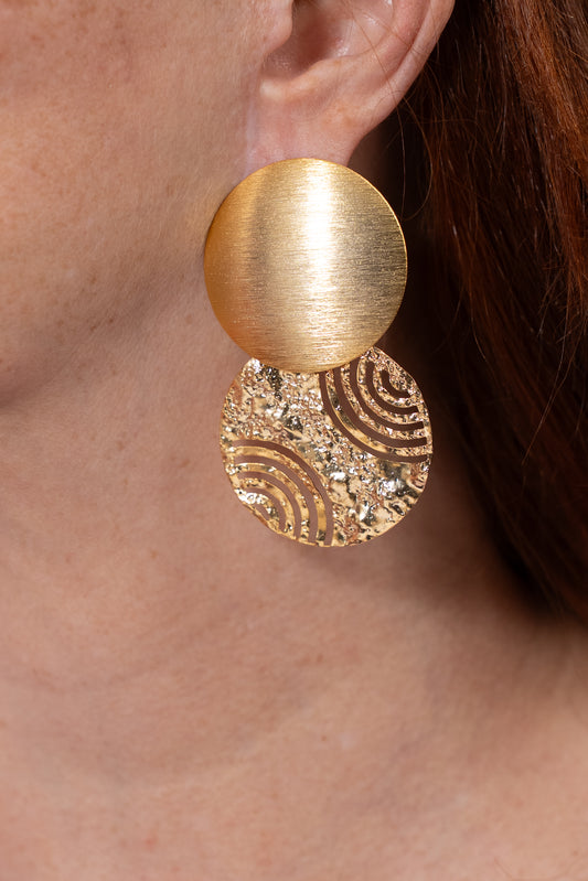 Aros dorados con dos piezas circulares: una lisa y una con textura decorativa.